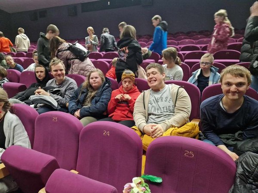 Na zdjęciu znajdują się uczniowie siedzący na sali kinowej.