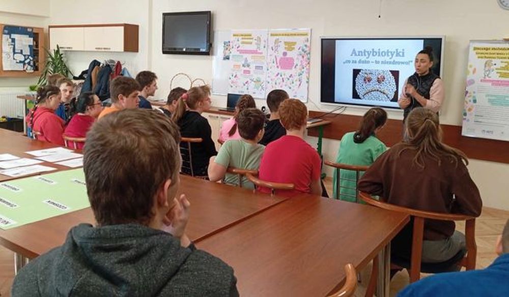 Na zdjęciu uczniowie siedzą zwróceni w stronę prezentacji o antybiotykach.