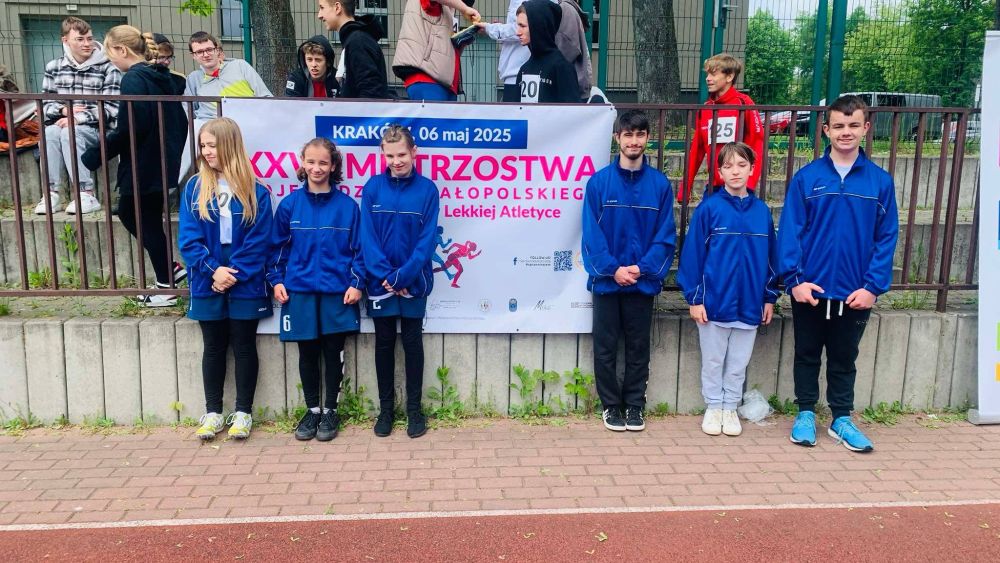 3 uczniów i 3 uczennice ubrani w niebieskie stroje stoją pod napisem Mistrzostwa w Lekkiej Atletyce.